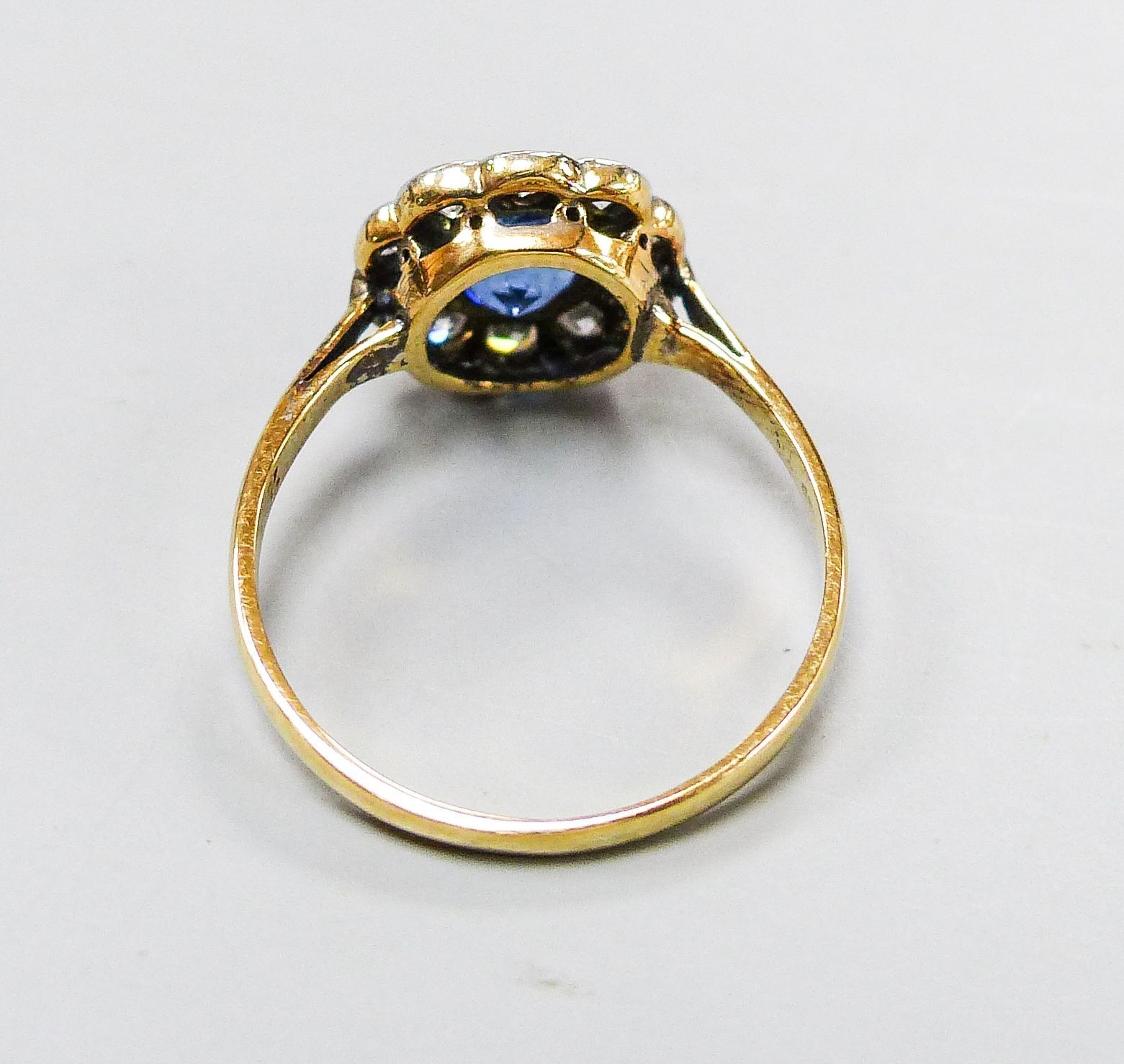 A yellow metal, sapphire and diamond cluster set flower head ring, size G, gross weight 1.6 grams.